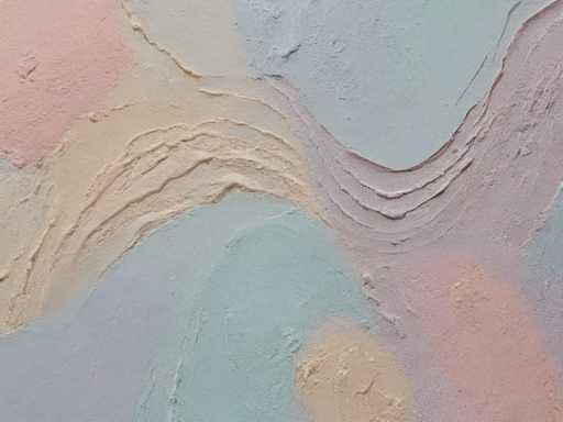 The image shows an abstract painting with a unique texture and color scheme. The background is a light beige color, providing a neutral backdrop for the vibrant colors of the paint. The paint appears to have been applied in a textured manner, creating a sense of depth and dimensionality. The predominant colors used are blue, green, pink, and white, which are arranged in a way that creates a harmonious balance within the composition.