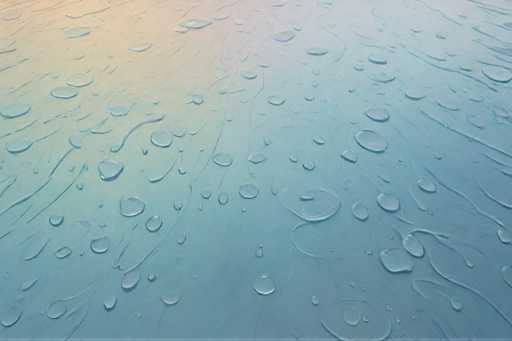 The image shows a close-up view of a blue surface with numerous water droplets scattered across it. The droplets vary in size and are located at different points on the surface, creating a sense of depth and texture. The background is a gradient transitioning from light to dark blue, providing a contrast that highlights the vibrant colors of the water droplets.